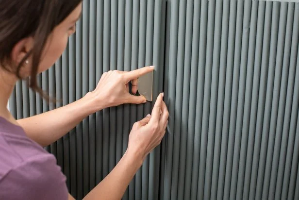 The next step in this DIY bold bar project is to fasten new brass hardware to the painted cabinets.